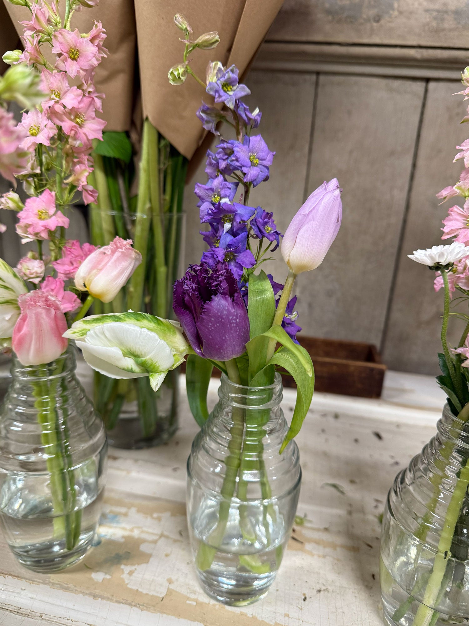 Vases with flowers on a wooden surface