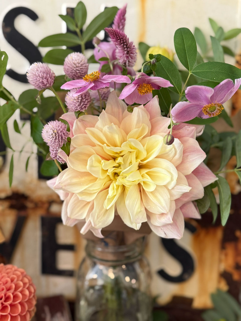 Bouquet of flowers in a vase with decorative letters in the background