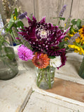 Bouquet of flowers in a clear vase on a wooden surface