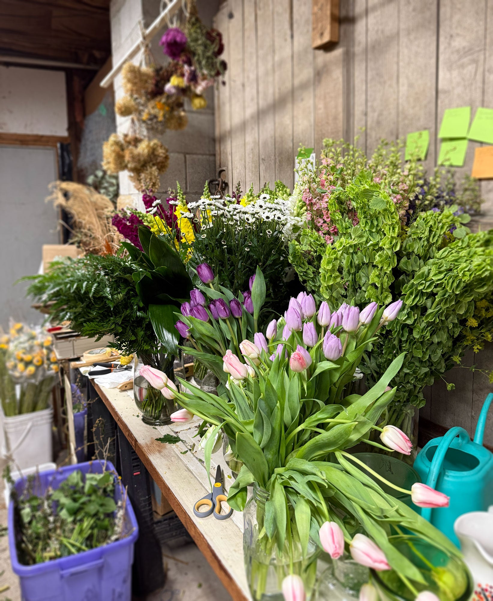 Floral arrangement workshop with tulips and other flowers on a table.