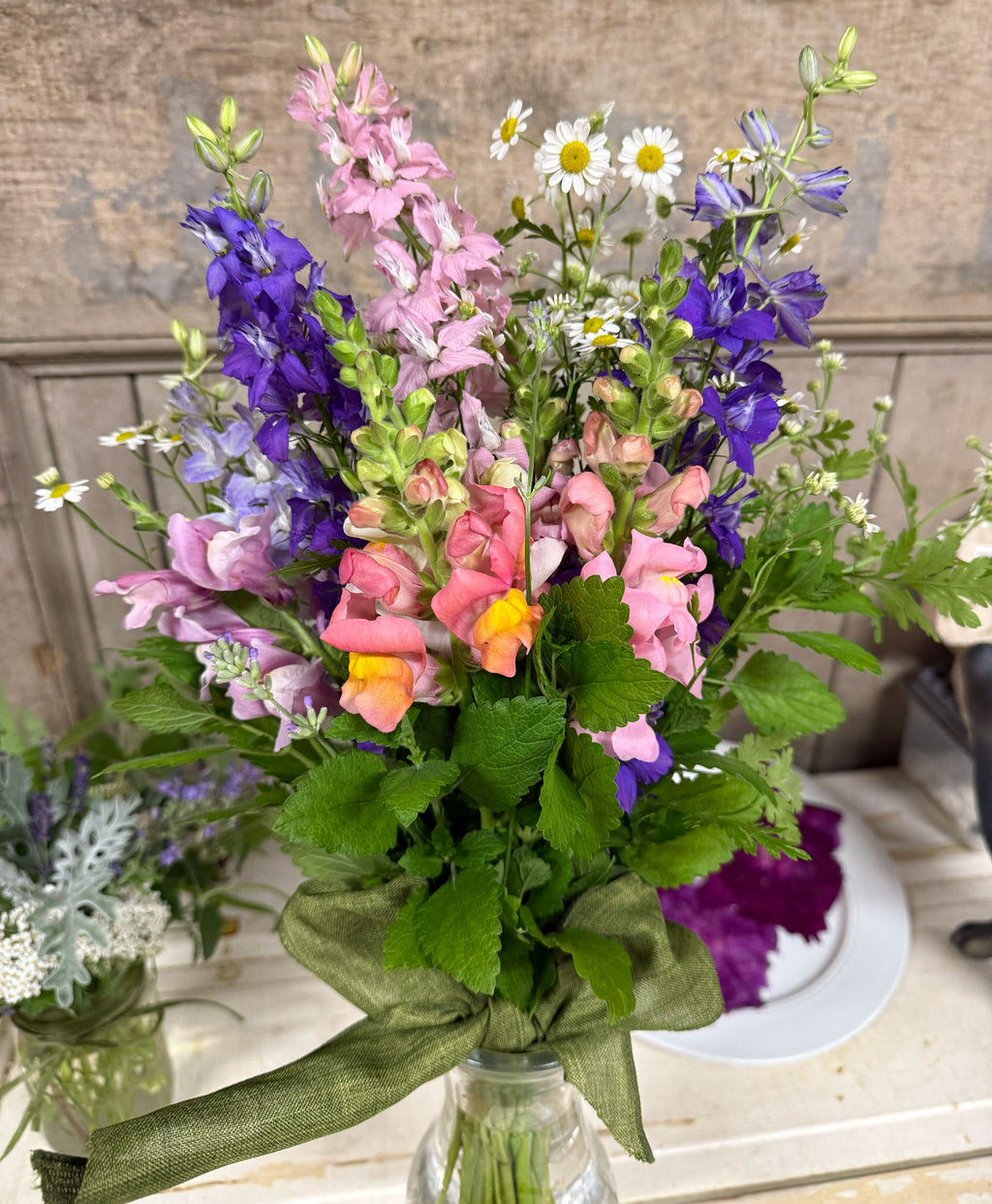 Bouquet of colorful flowers in a clear vase on a wooden surface.