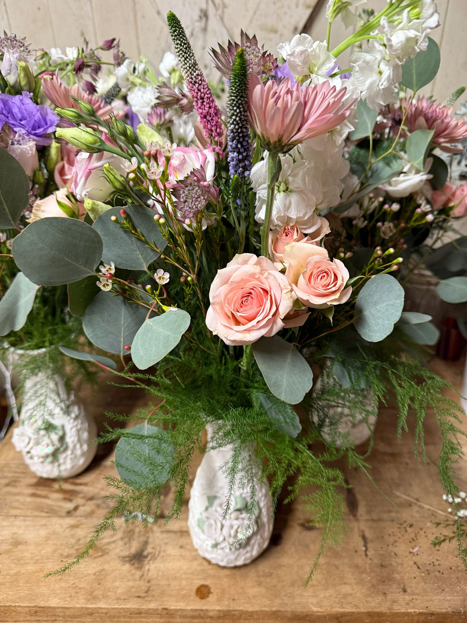 Bouquet of flowers in a decorative vase on a wooden surface